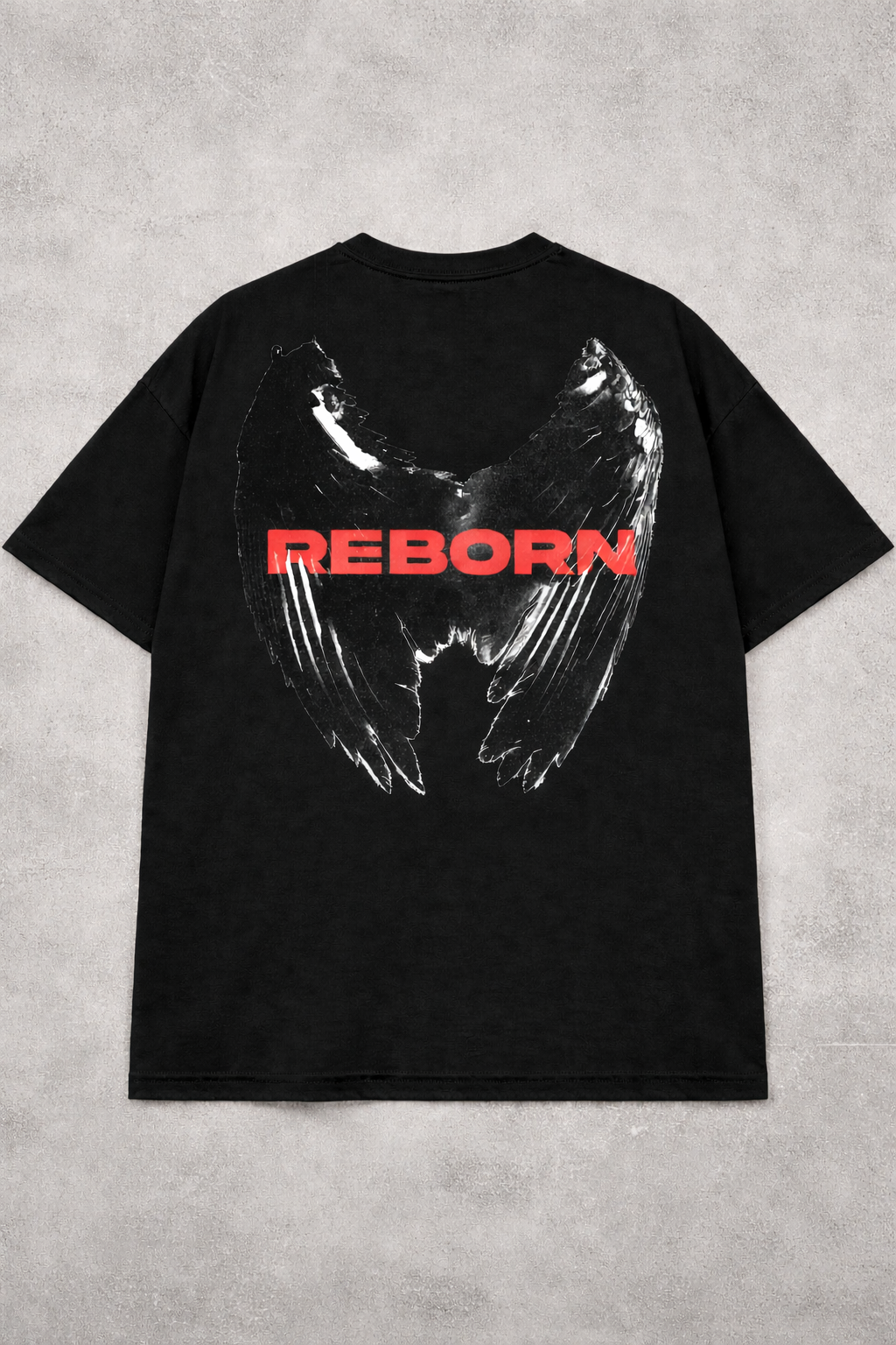 Black t-shirt with wings and 'REBORN' text on a gray concrete background
