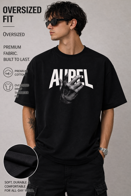 Man wearing an oversized black t-shirt with a graphic design on a gray background