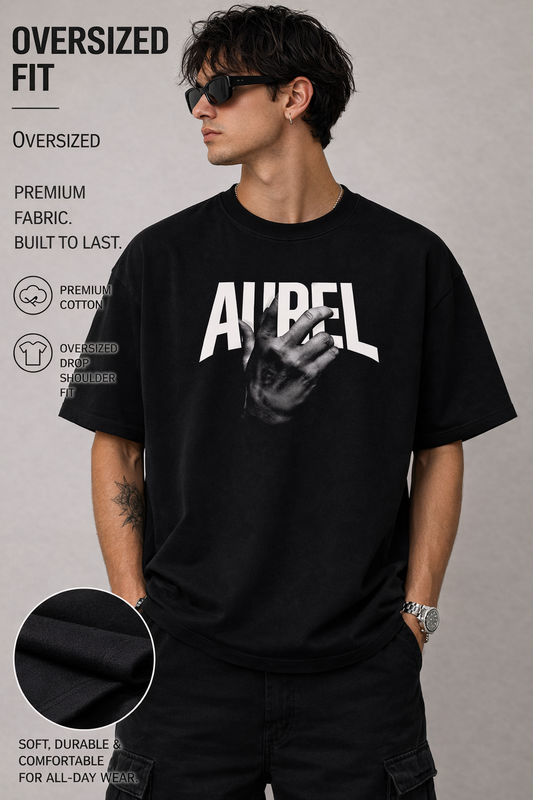 Man wearing an oversized black t-shirt with a graphic design on a gray background