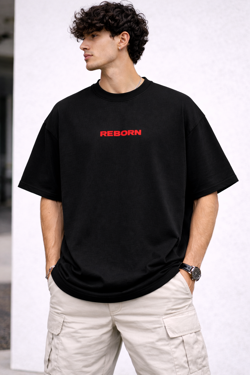 Man wearing a black t-shirt with 'REBORN' in red text on a white background