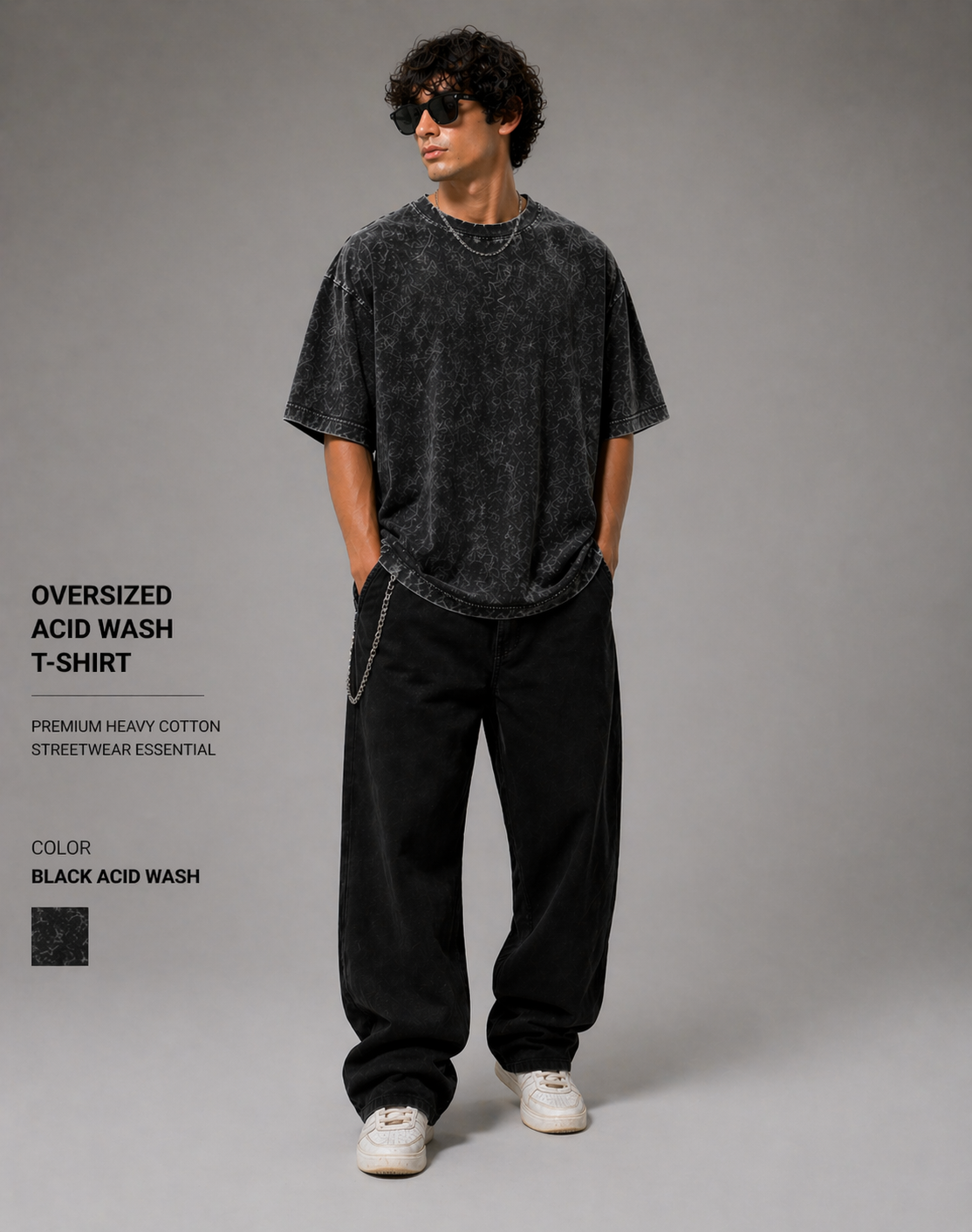 Person wearing an oversized acid wash t-shirt and black pants on a gray background