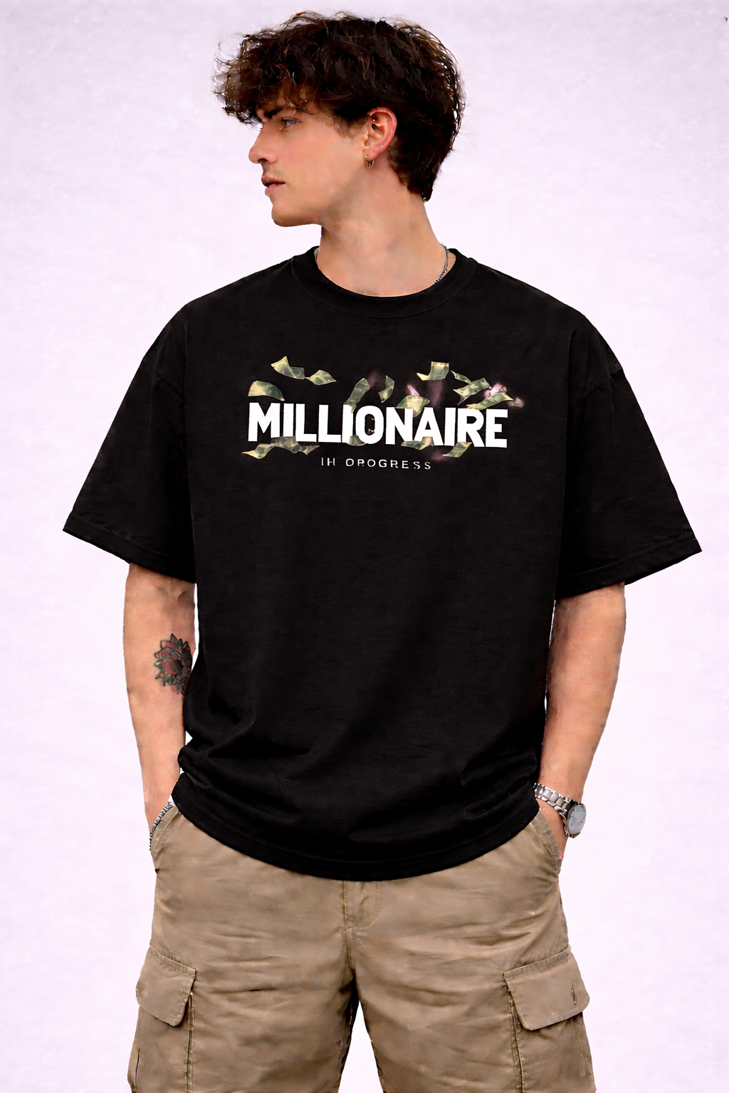 Person wearing a black t-shirt with 'Millionaire In Progress' text on a white background