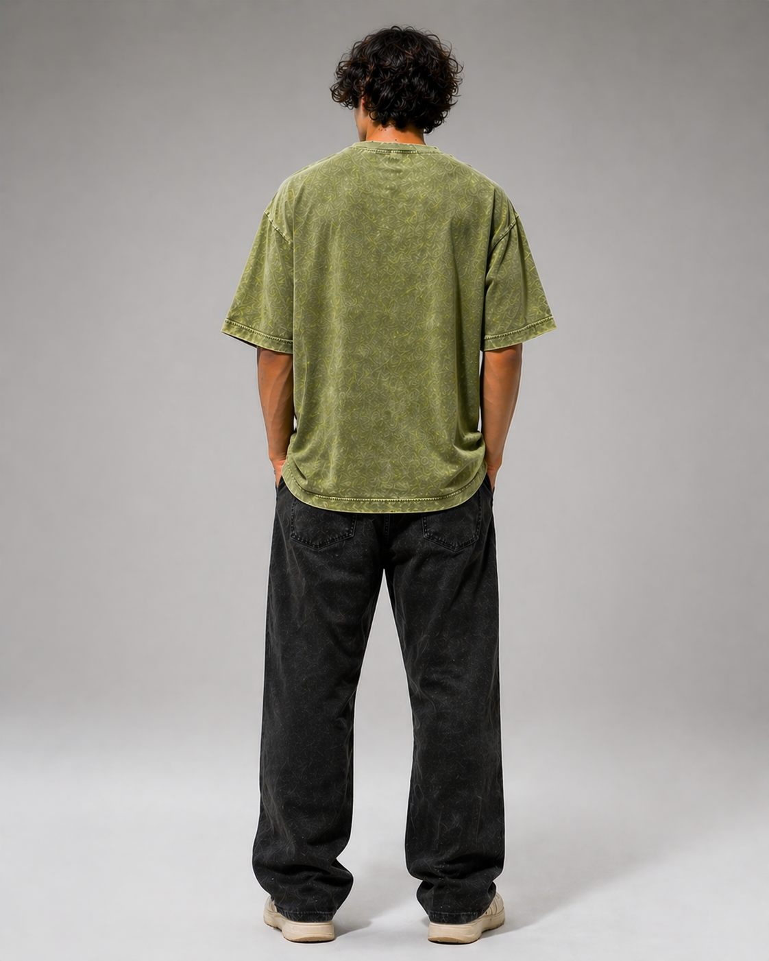Person wearing a green t-shirt and black pants on a gray background