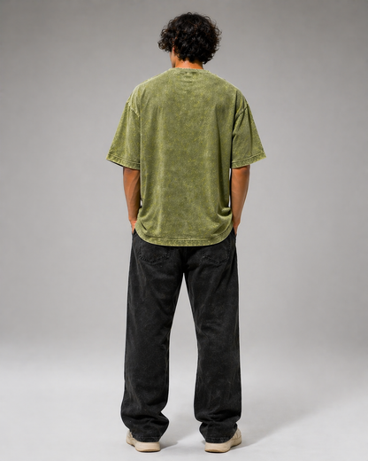 Person wearing a green t-shirt and black pants on a gray background
