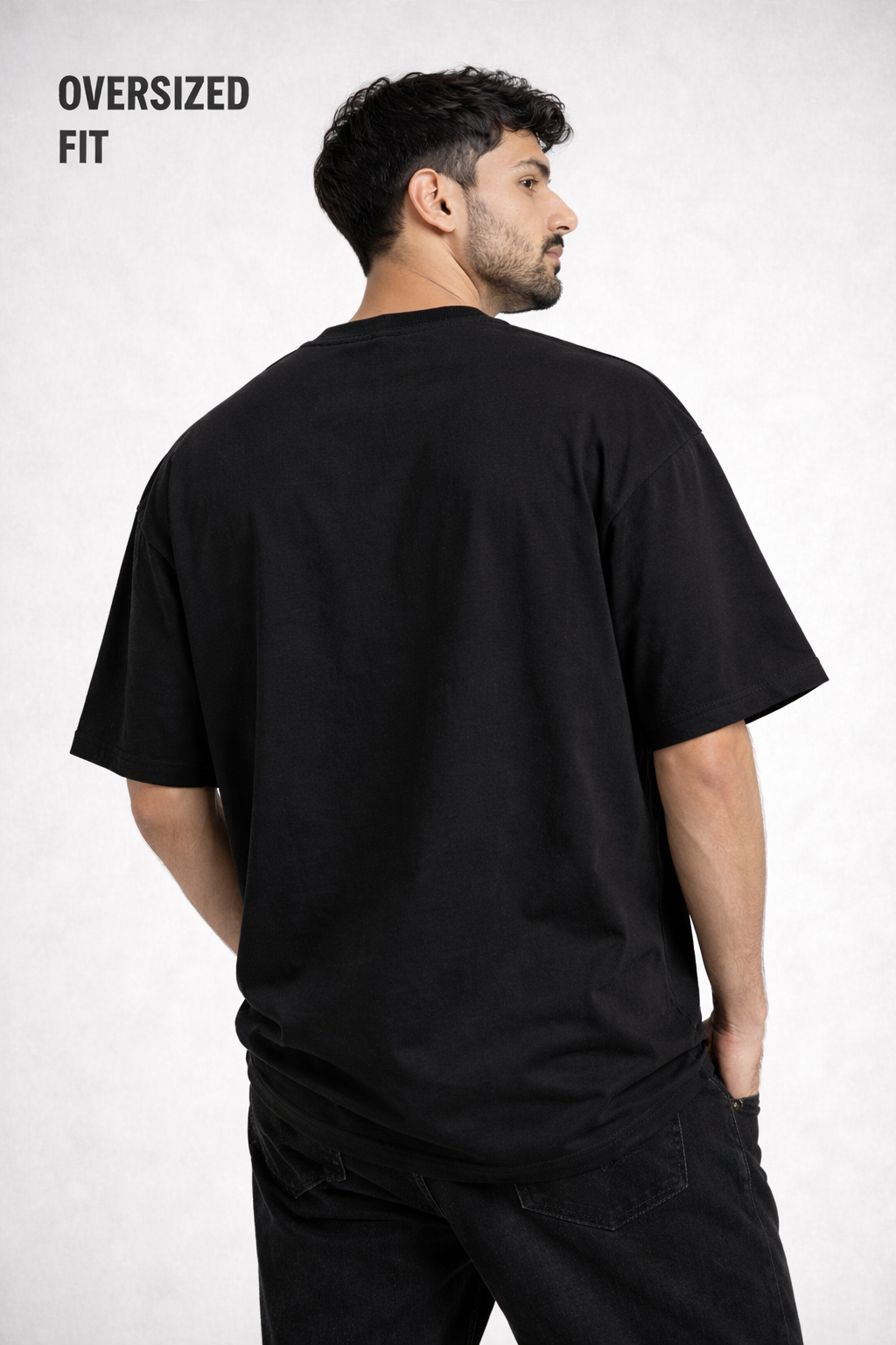 Man wearing an oversized black t-shirt on a white background