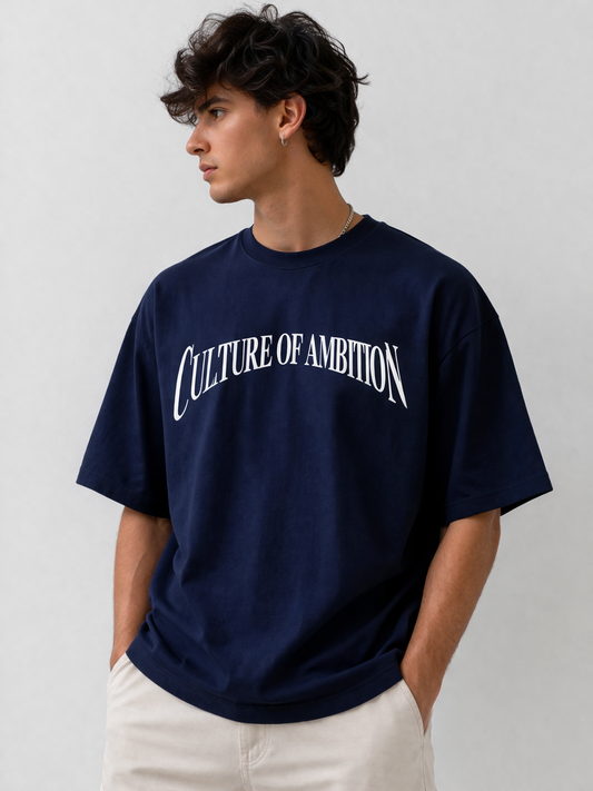 Person wearing a navy blue t-shirt with 'Culture of Ambition' text on a plain background